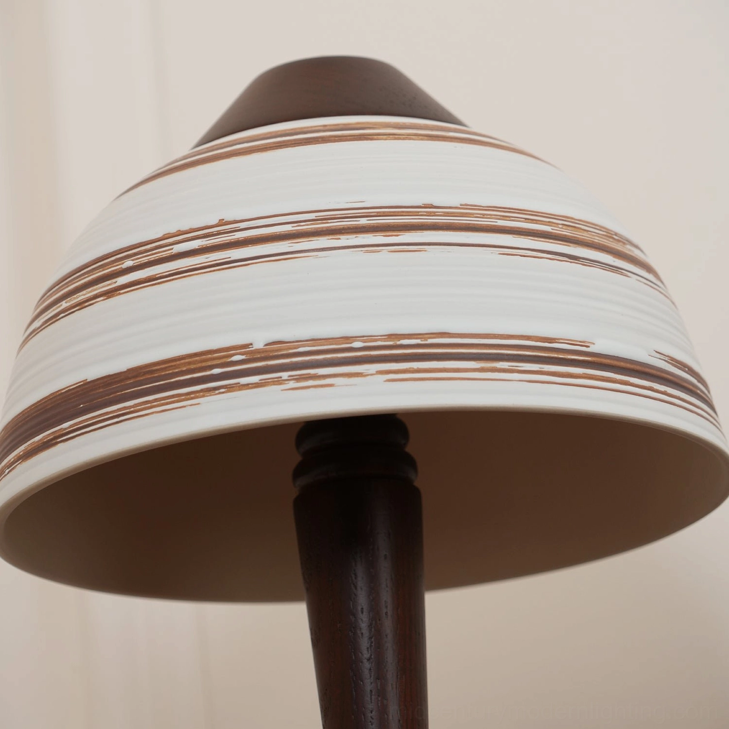 Under-shade close-up of Athena lamp showing dark brown interior and white ceramic exterior with brown stripe texture