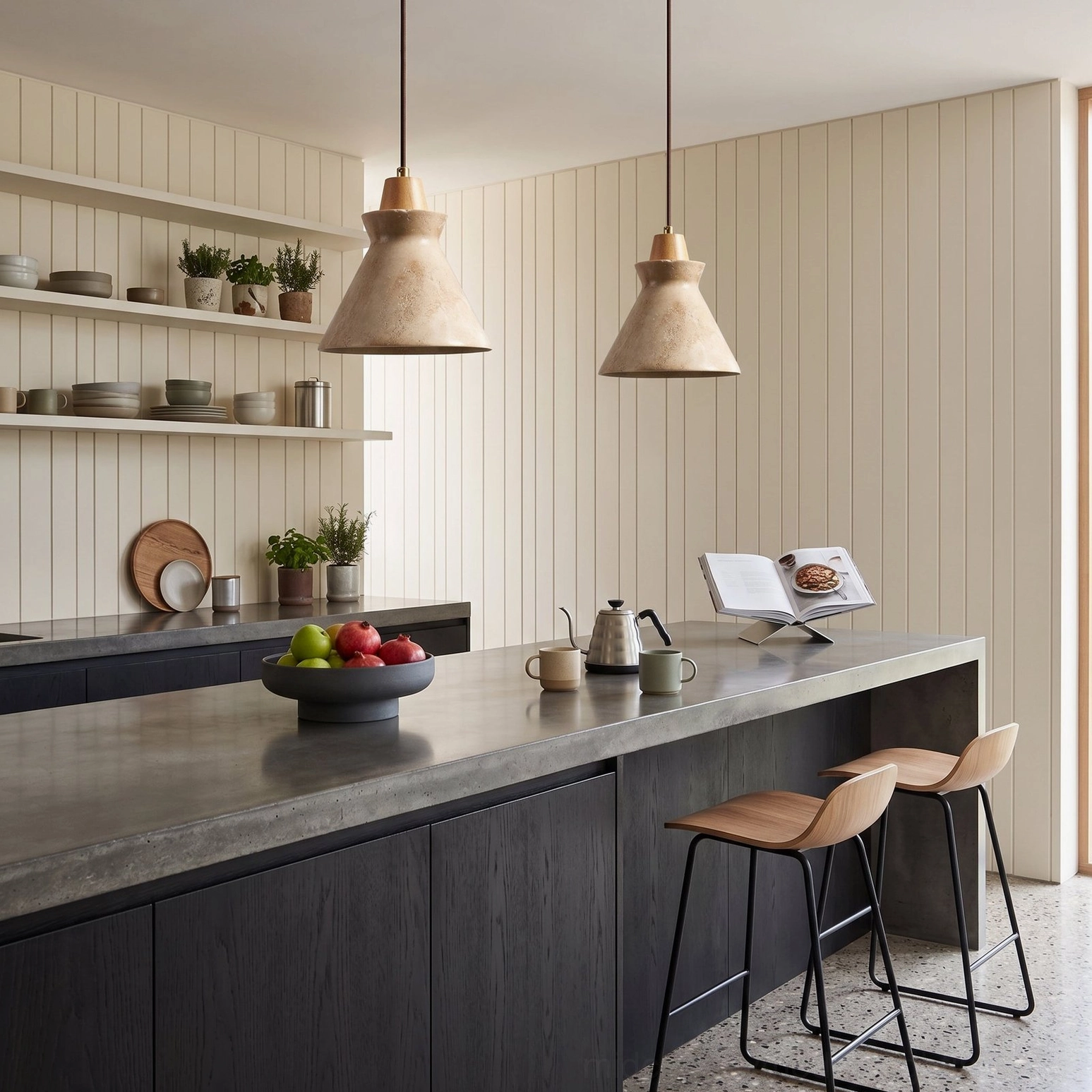 Two Athena travertine stone pendants above kitchen island with dark cabinetry and concrete countertop