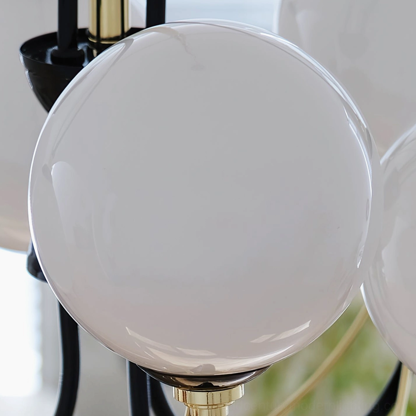 Close-up macro view of frosted white glass lamp globe with gold fixture base on Atomic Orbit Chandelier