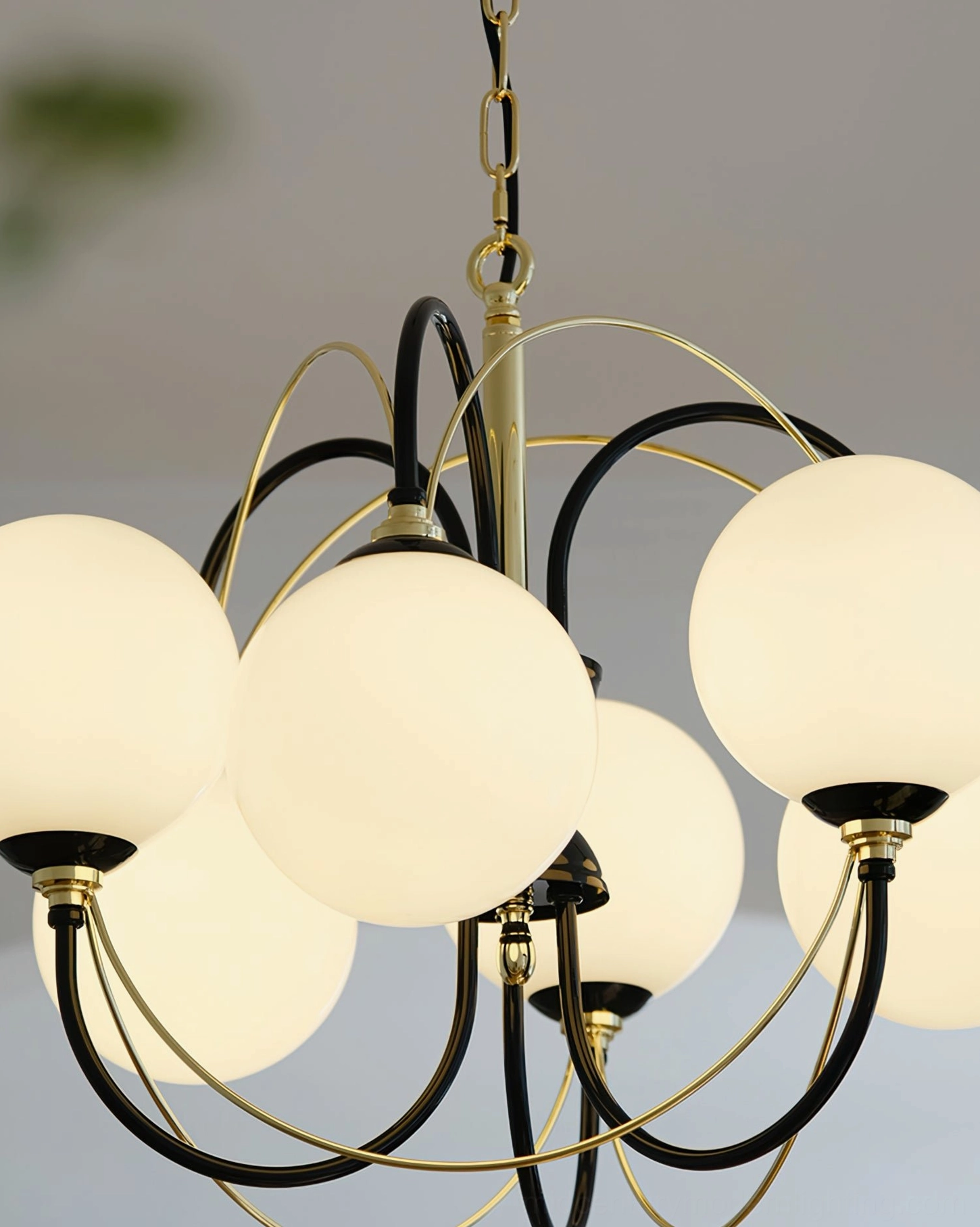 Low angle close-up of lit Atomic Orbit Sputnik chandelier with warm glowing glass globes in minimalist space