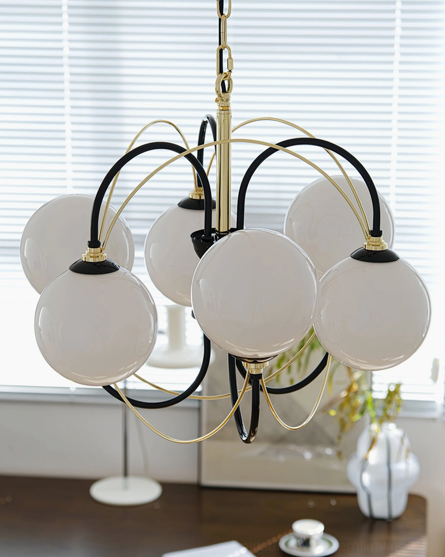 Atomic Orbit glass ball chandelier three-quarter view, six white globes with black-gold metal frame in home workspace