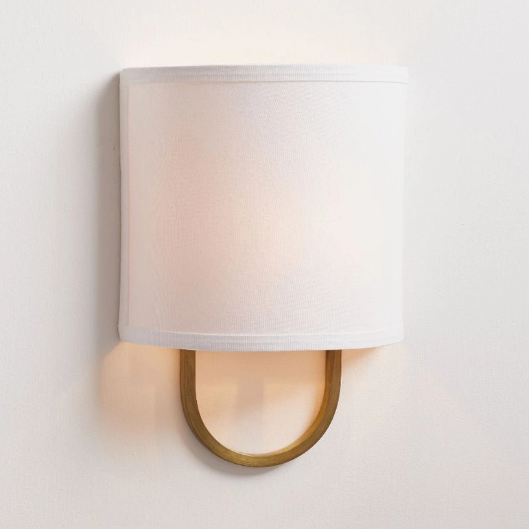Brass Atticus wall lamp with oversized off-white drum shade, minimalist mid-century design detail shot