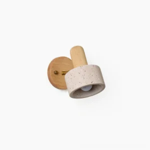 Aureole organic modern wall sconce with travertine shade and light wood backing, three-quarter close-up view on plain background