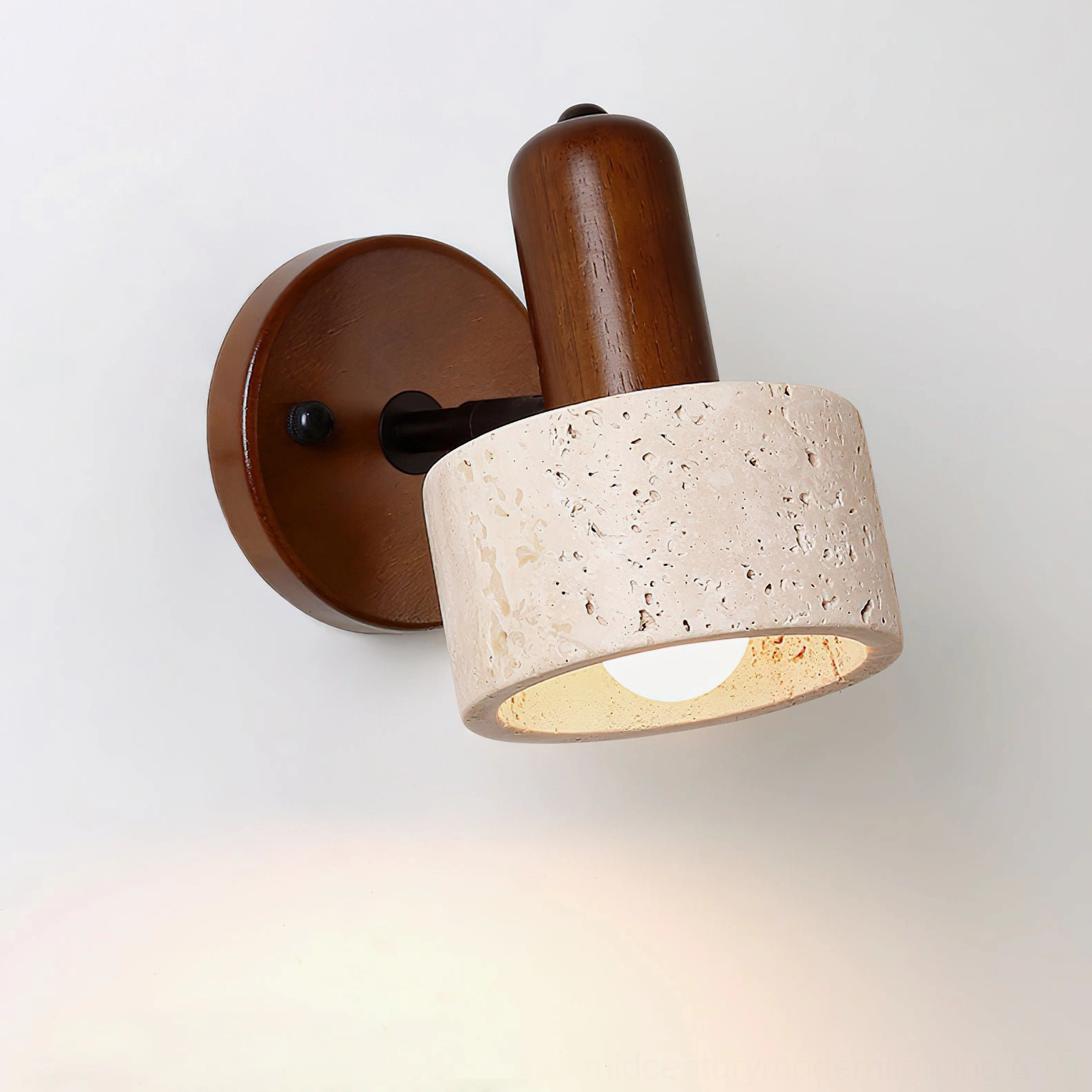 Aureole illuminated wall sconce side view showing warm ambient light through travertine shade