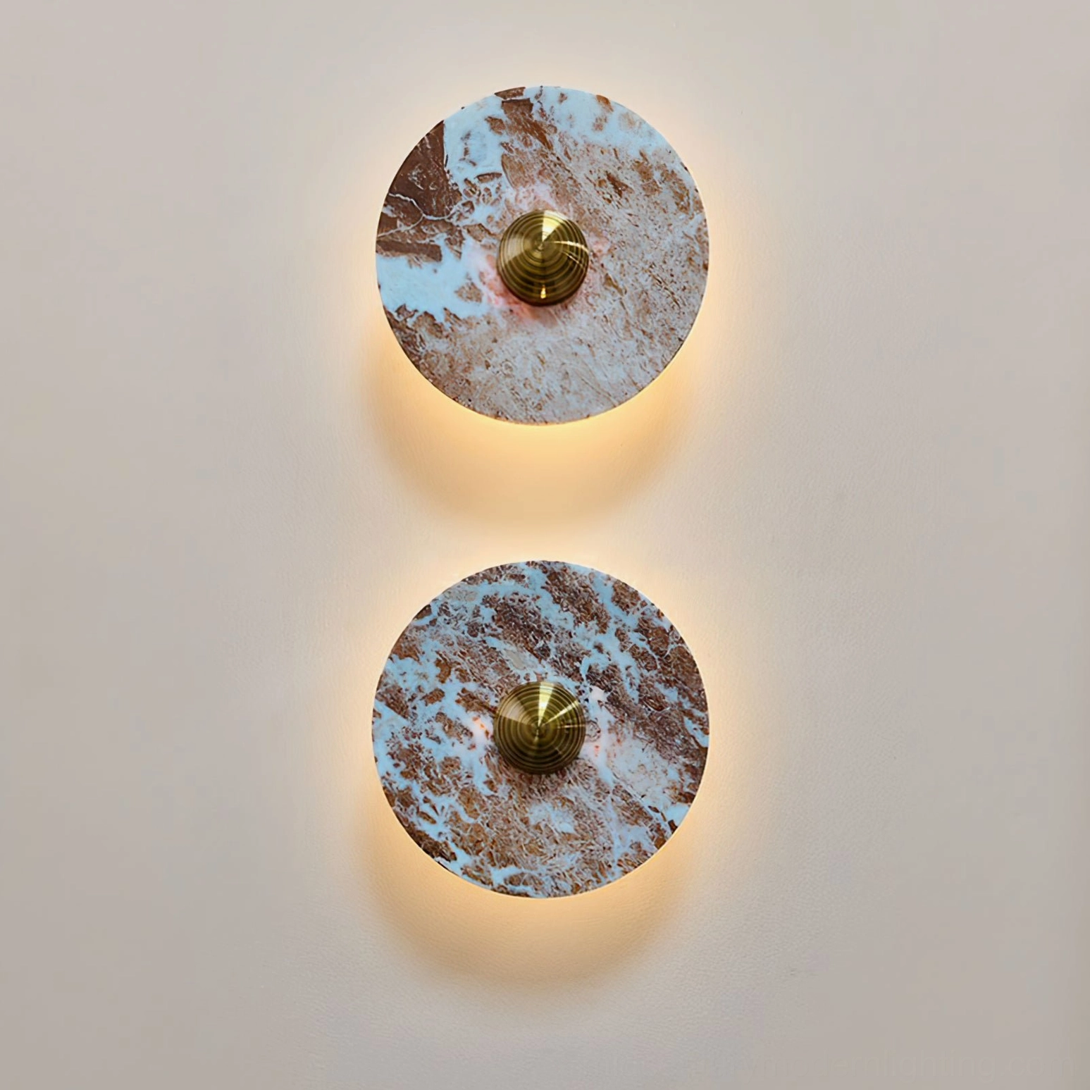Illuminated Aurora marble wall lamps glowing warm light on beige interior wall at dusk