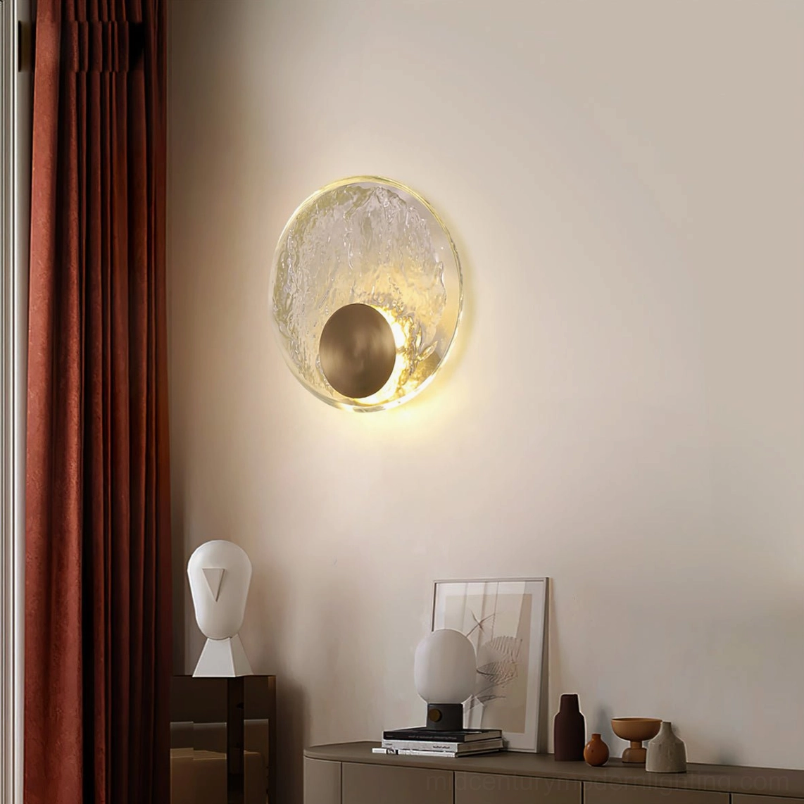 Decorative brass wall light fixture in minimalist bedroom with dark red curtains and wooden furniture, circular glass design