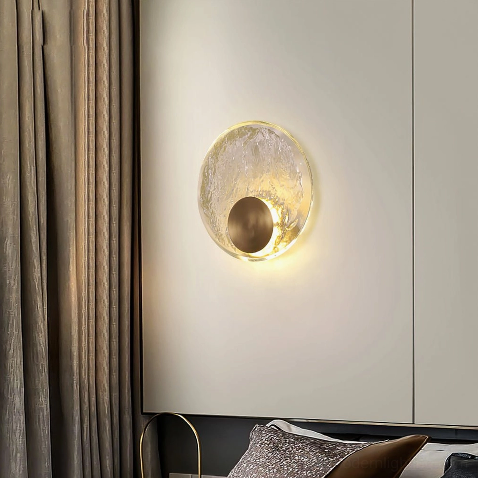 Round brass wall lamp in bedroom corner with built-in wardrobe, beige curtains, and textured throw pillows, modern home lighting