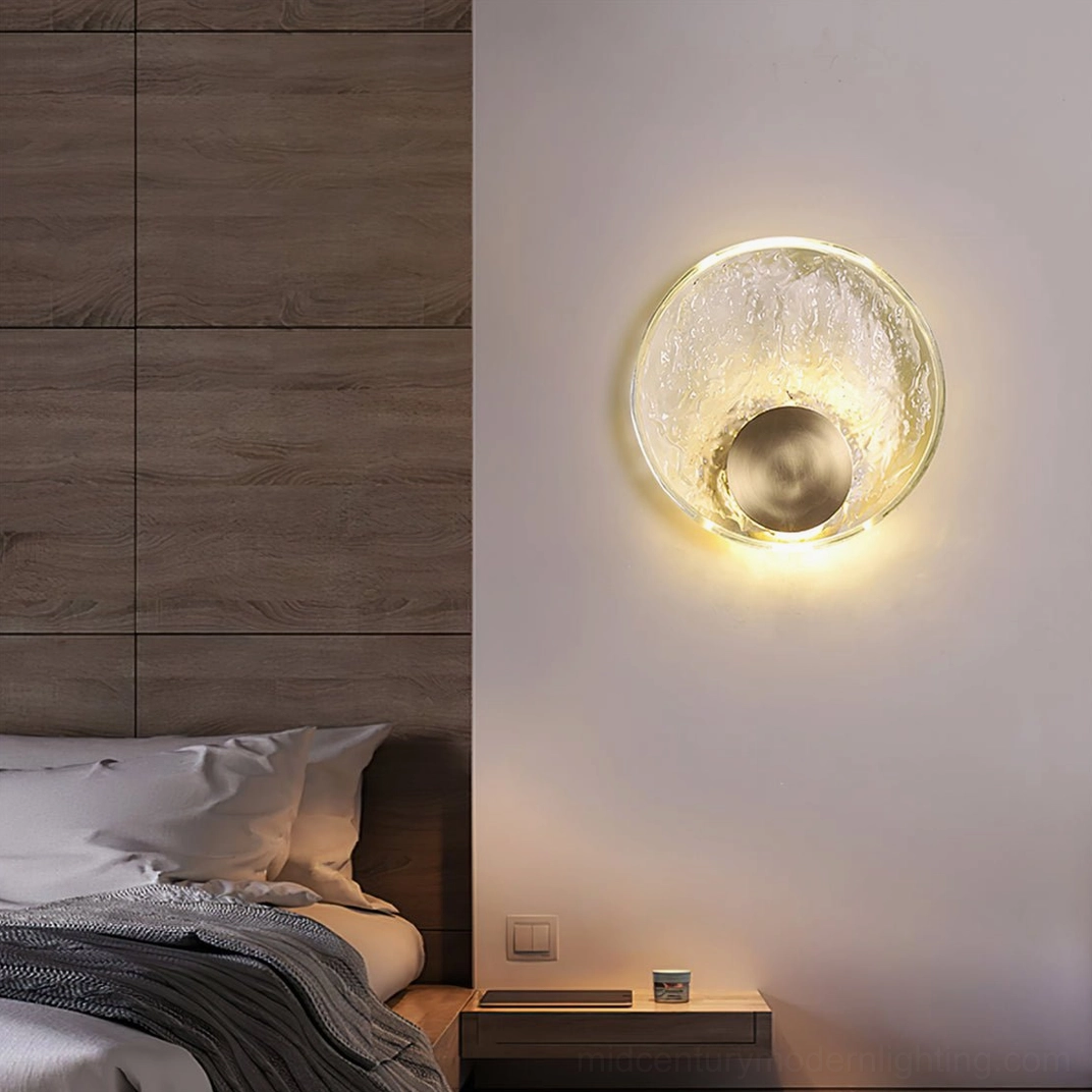 Aurum wall mounted brass sconce in modern master bedroom with wood panel walls and neutral bedding, mid-century lighting