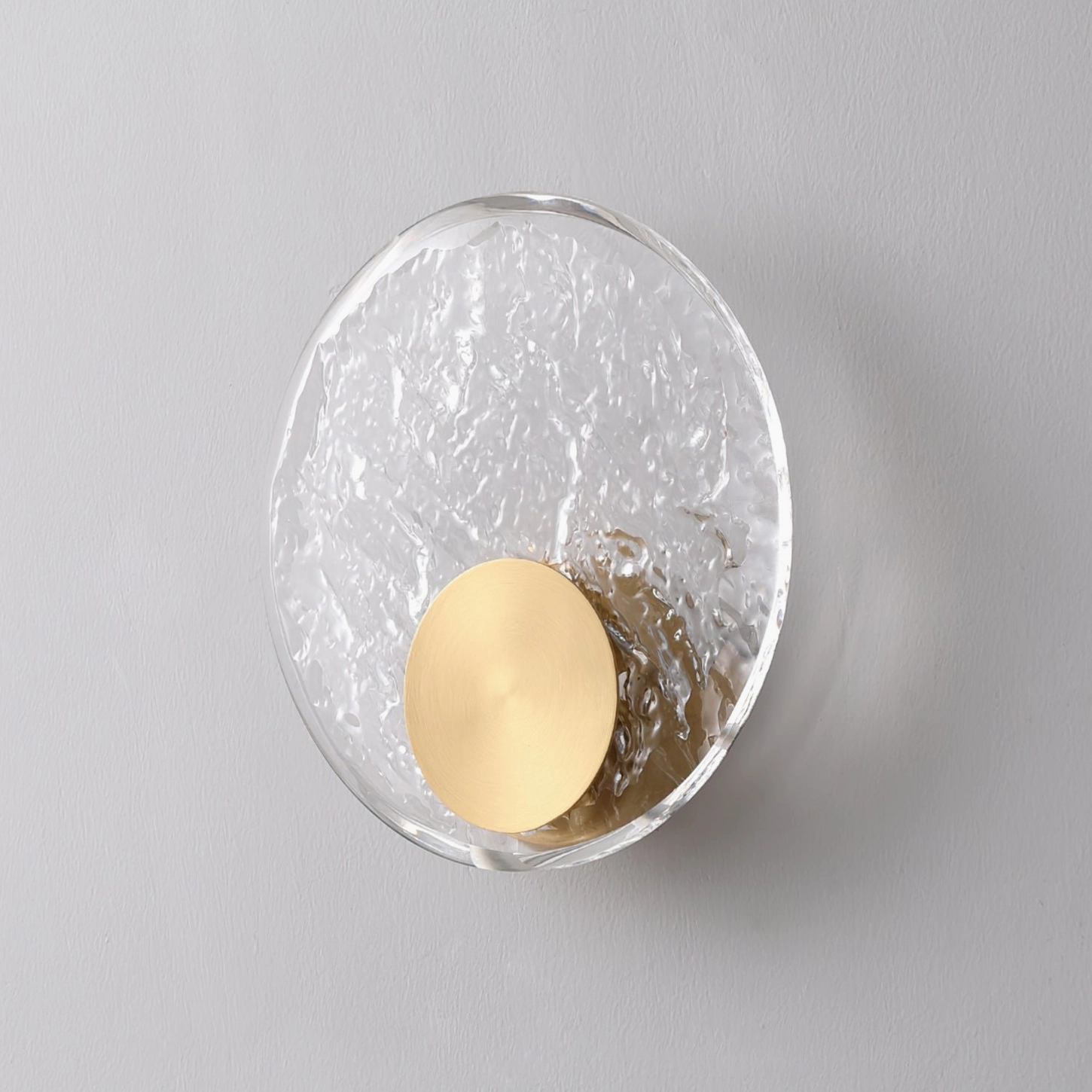 Aurum wall sconce product detail showing brass construction, crystal glass shade, and warm light diffusion