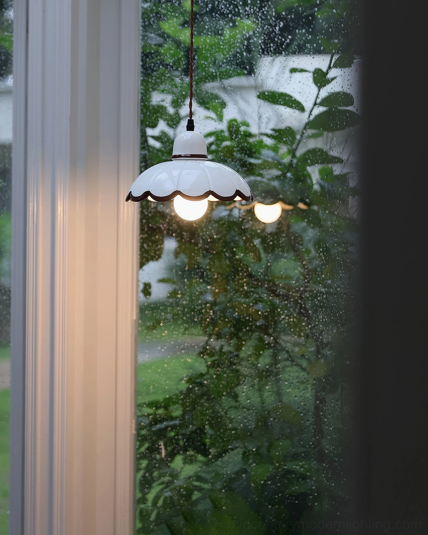 Multiple Avalon pendant lights in outdoor garden setting with lush green foliage