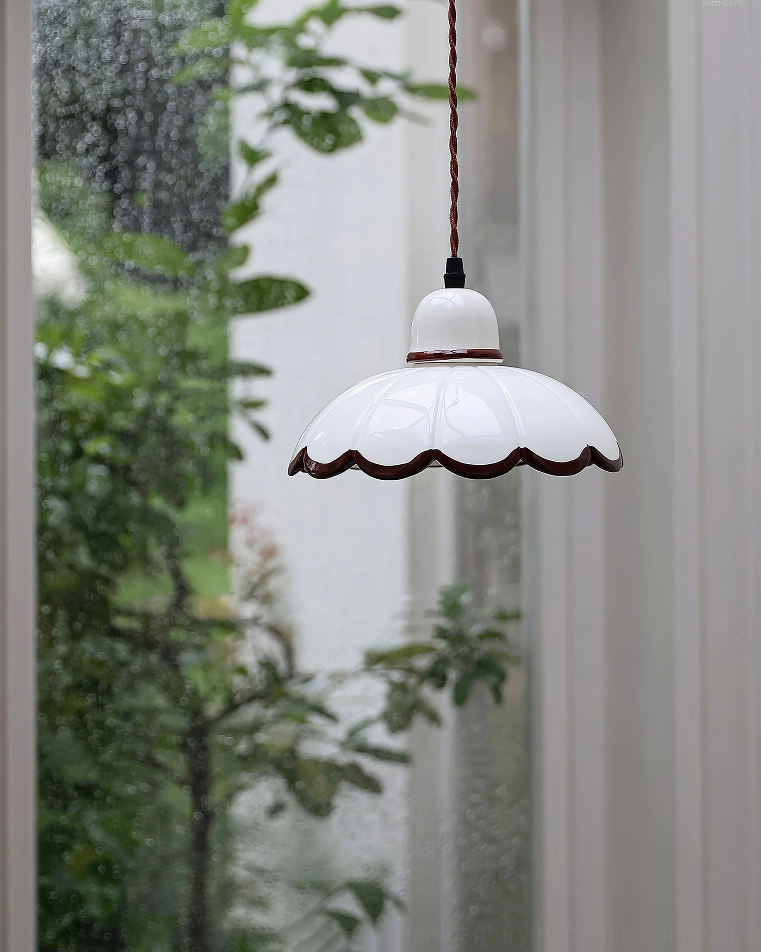 Single Avalon scalloped pendant light illuminated indoors with sheer curtains