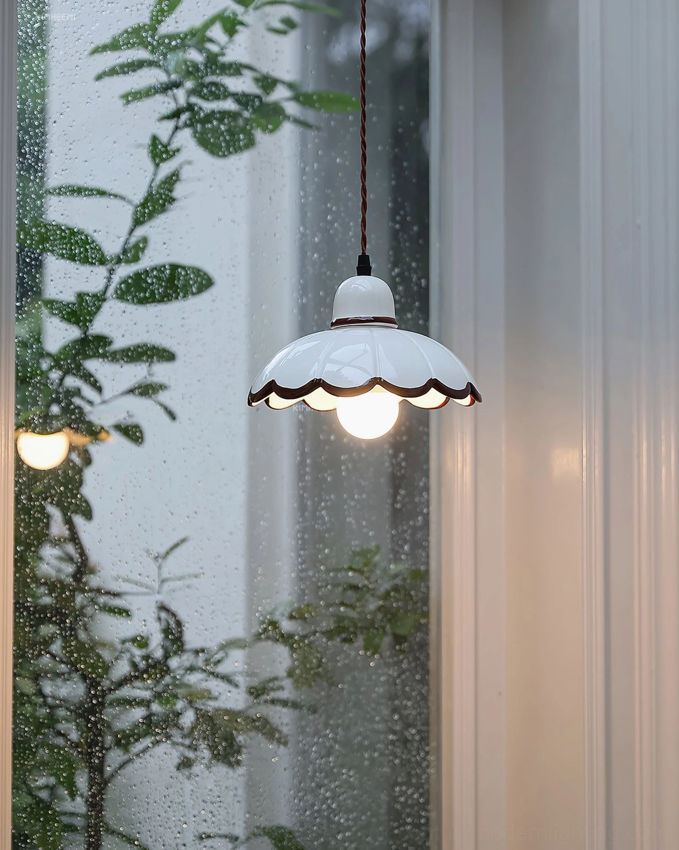 Avalon ceramic pendant light glowing with warm light, close-up side angle view
