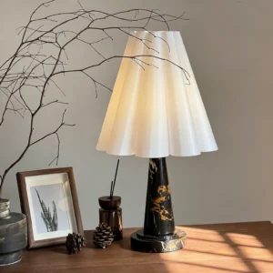 Aveline pleated table lamp lit with warm light on wooden table, mid-century modern lamp creating soft ambient glow