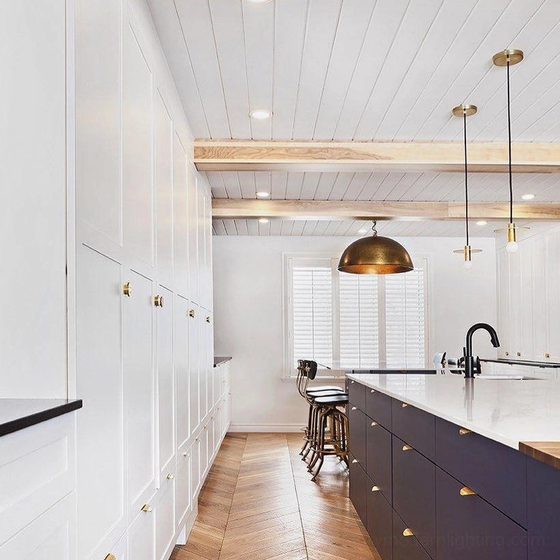 Avida brass dome pendant light in luxury farmhouse kitchen with herringbone wood flooring and marble countertop