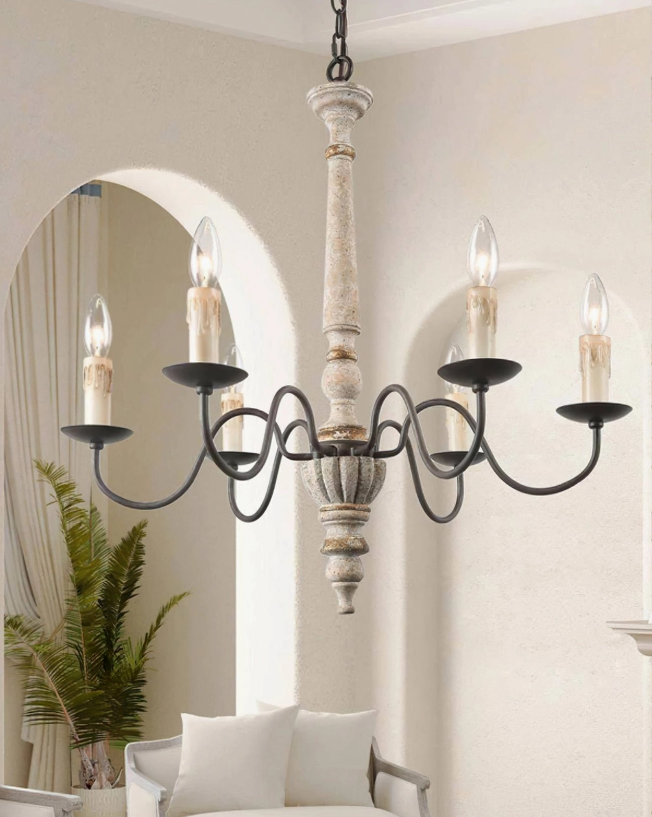 Avignon distressed white wood chandelier in cozy sitting area with arched doorway, coastal farmhouse aesthetic angled room view
