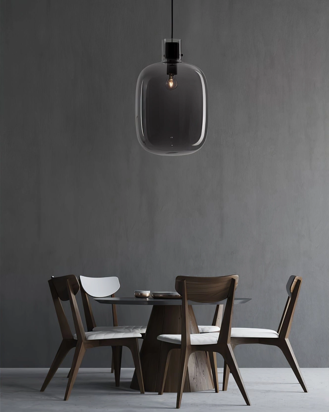 Single Awa pendant light with smoke grey oblong blown glass shade, matte black ceiling fixture, studio product showcase
