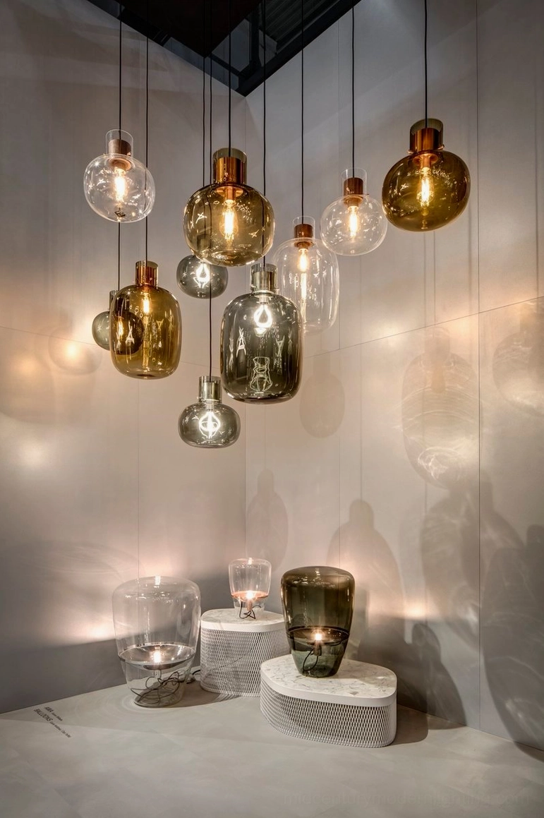Assorted Awa pendant lights with amber and smoke grey hand-blown glass shades, warm mood lighting in cozy lounge