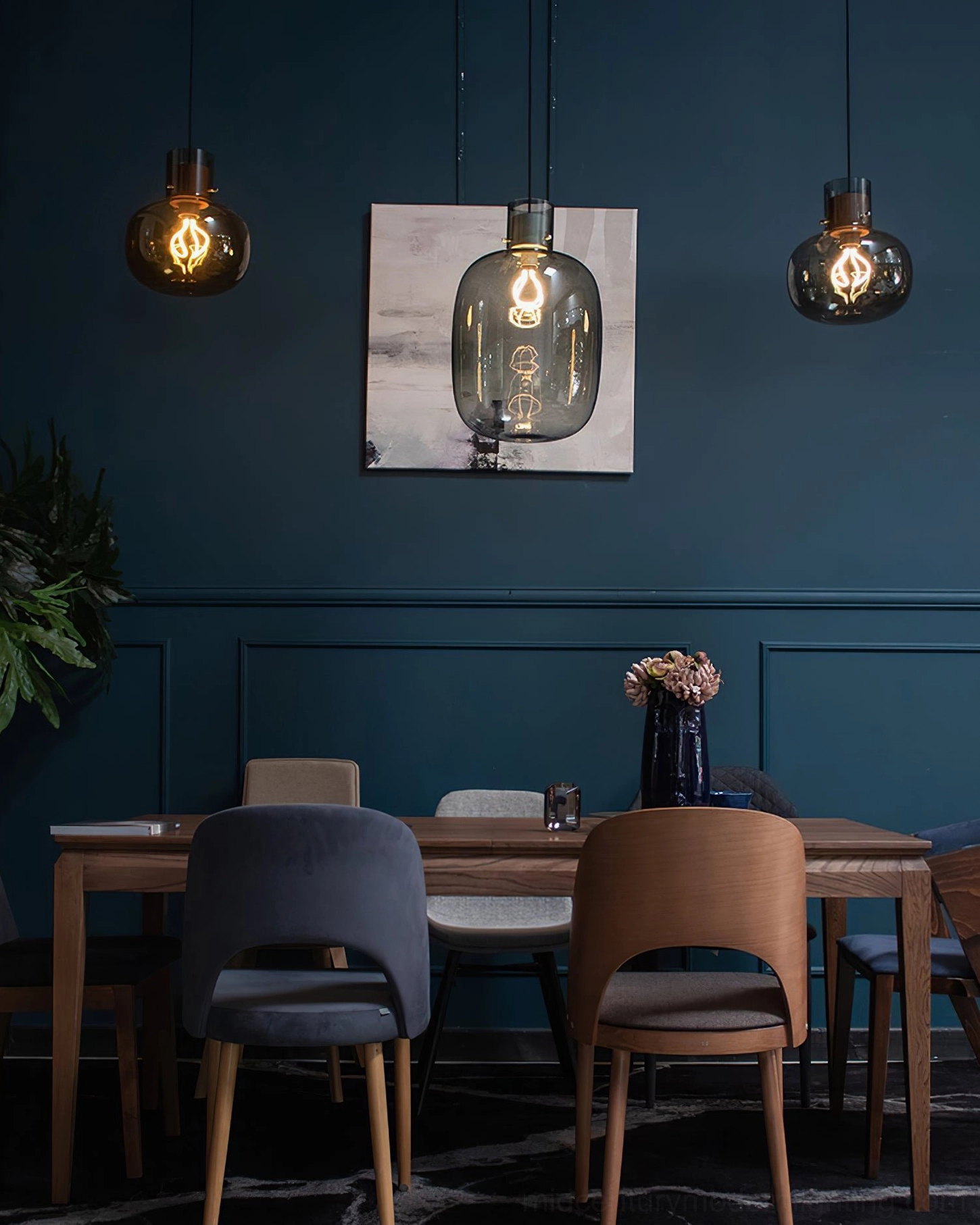 Matching Awa pendant lights with dark smoke grey glass over modern dining room, warm filament bulbs, teal accent wall