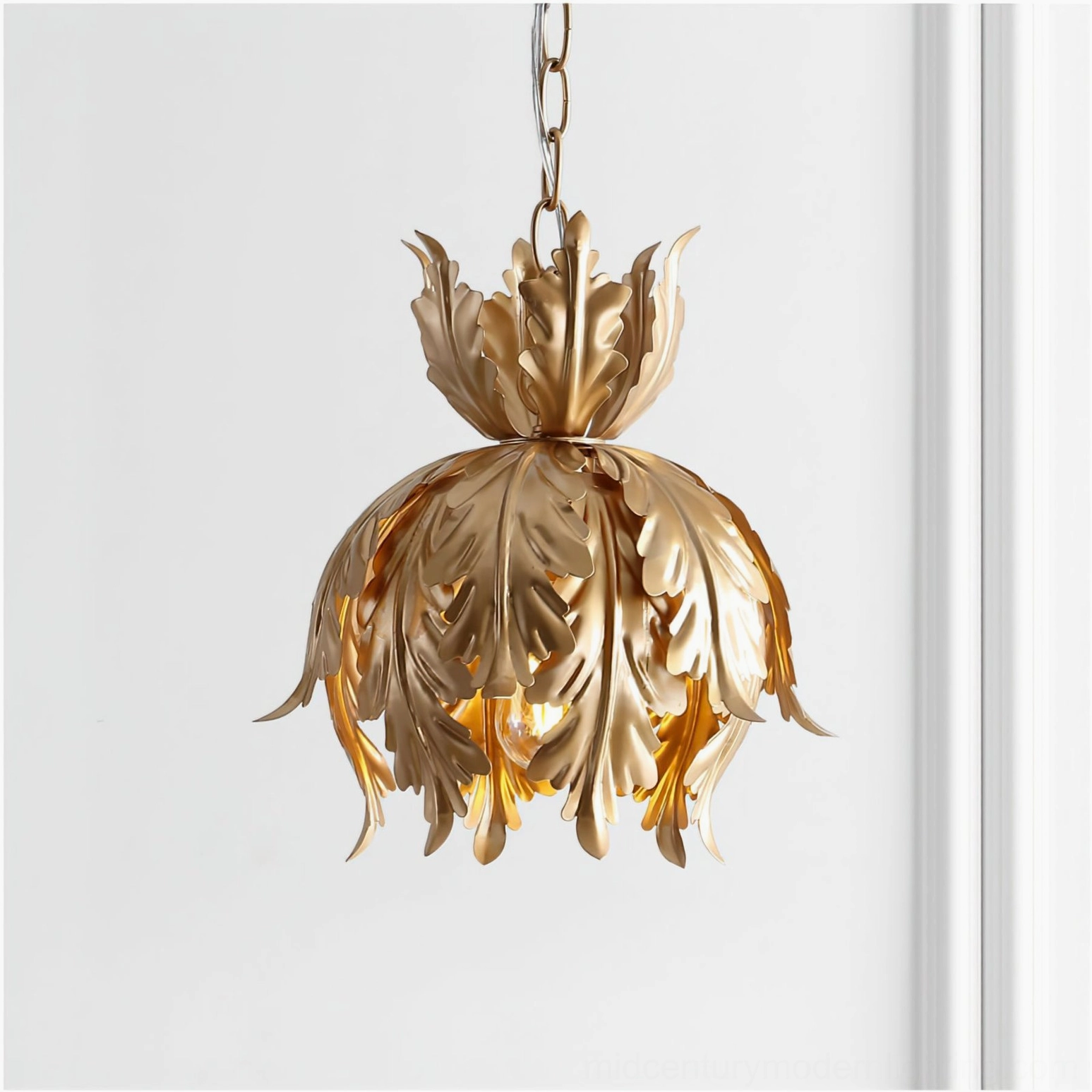 Illuminated Azalea gold leaf pendant with glowing warm light creating atmospheric shadows on paneled white wall