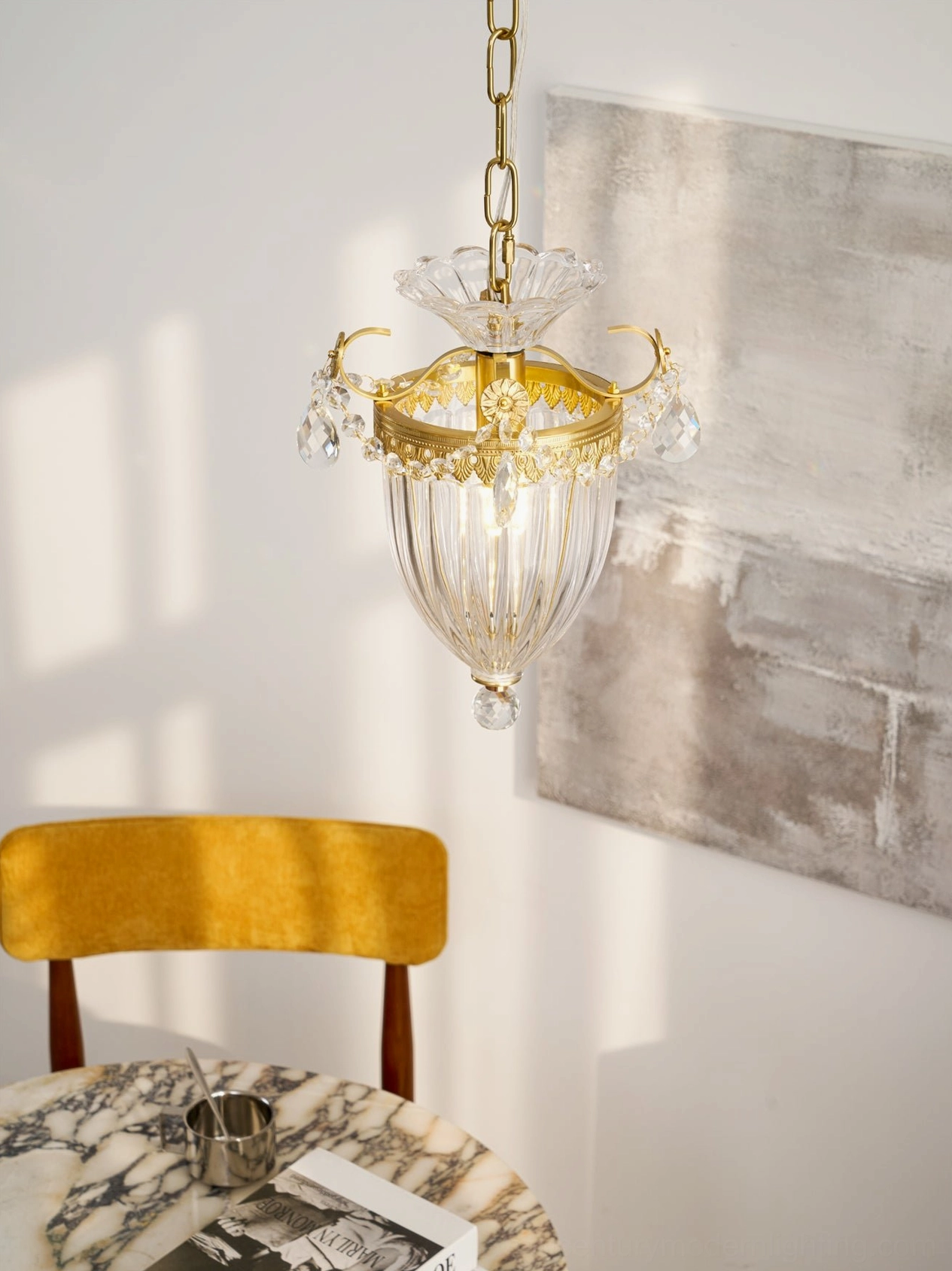 Bagatelle brass pendant light above dining table with marble and modern decor