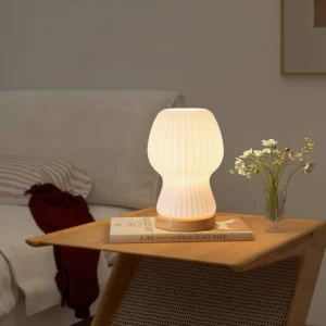 Baja table lamp on bedroom nightstand with book and flower vase, warm ambient lighting