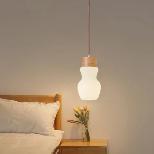Baja pendant light suspended in bedroom bedside area casting warm ambient glow with wood accents