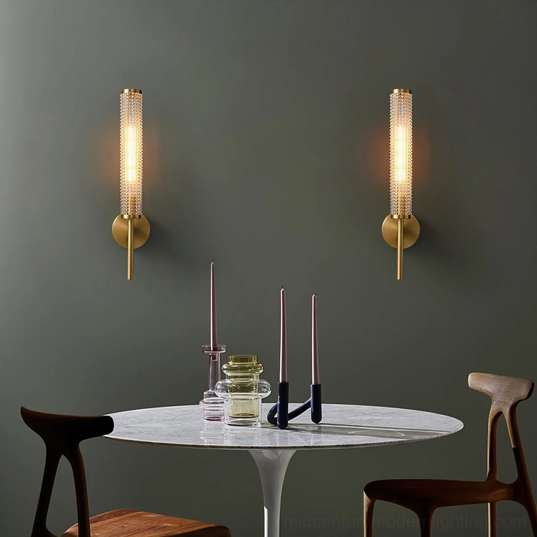 Pair of Baldassare brass sconces illuminating modern dining nook with green accent wall