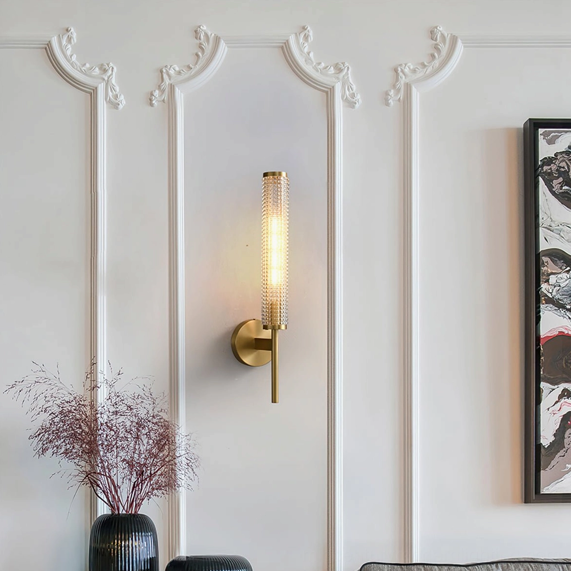 Baldassare brass wall fixture above gallery art and luxury paneled wall
