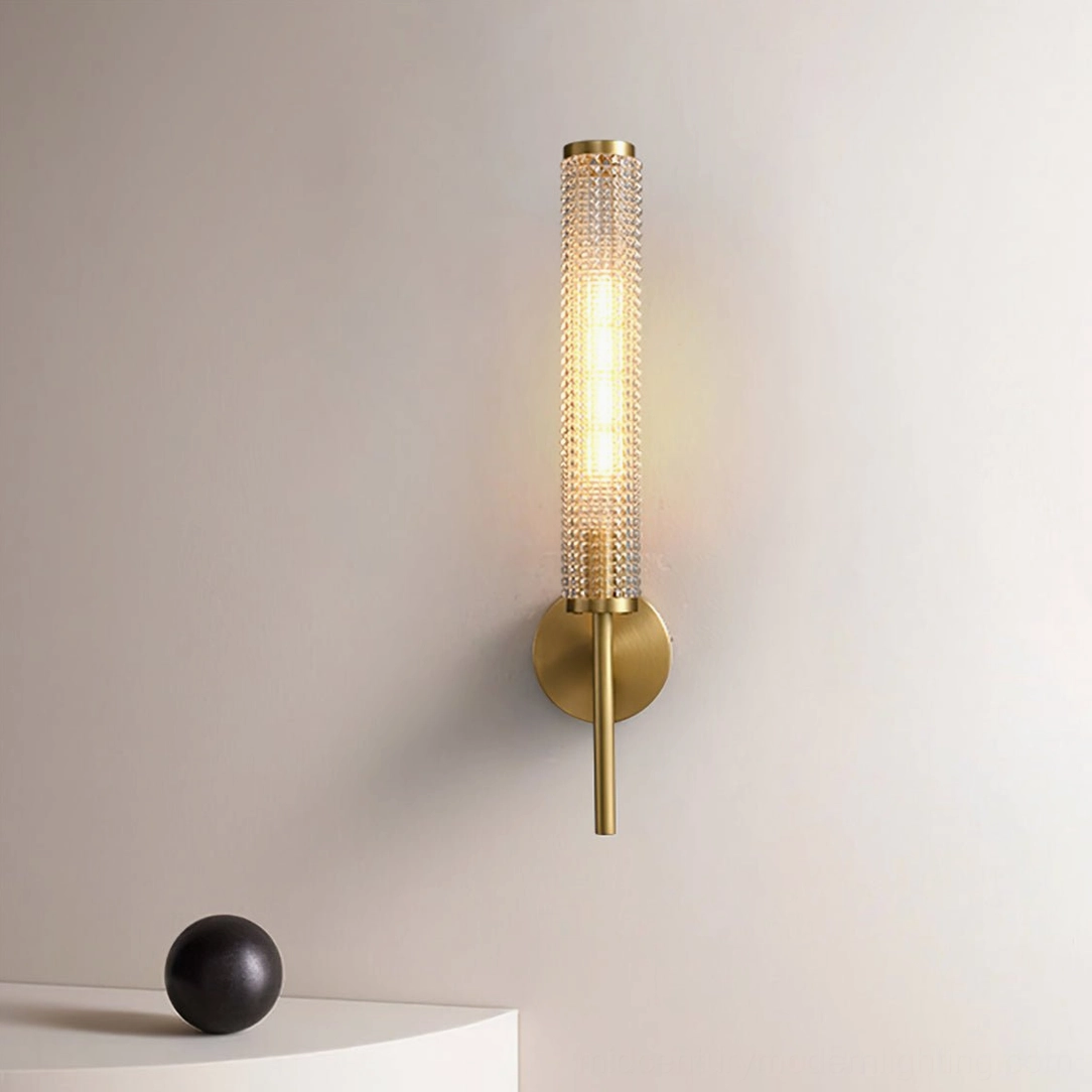 Baldassare wall lamp lit in bedroom bedside setting with warm ambient glow