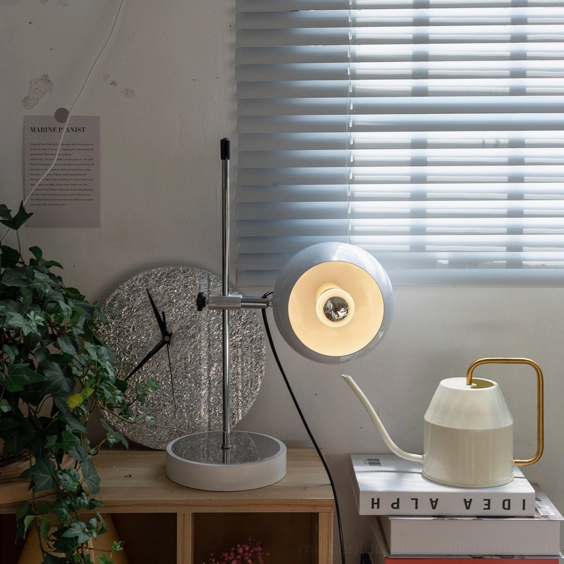 Nordic minimalist ball bracket desk lamp close-up with polished silver metal frame and books