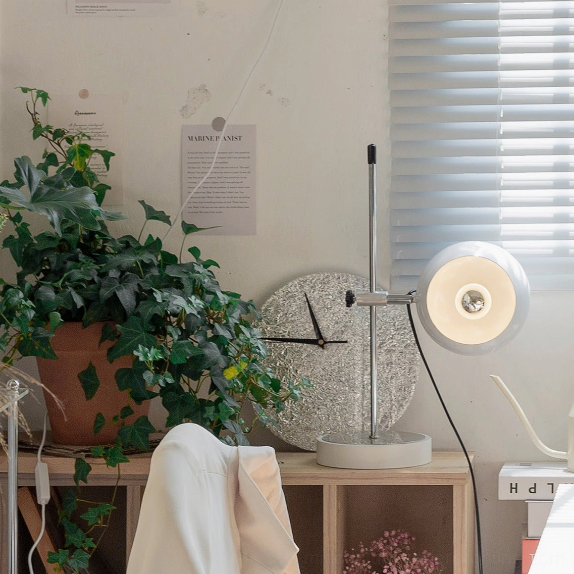 Illuminated flat round ball bracket lamp shade in modern home workspace with potted plant