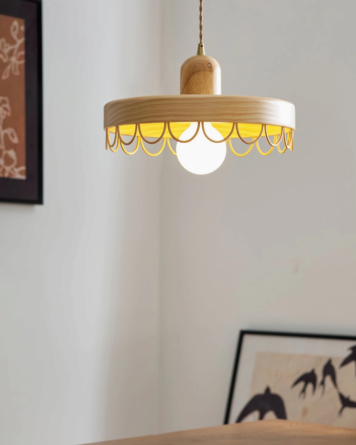 Light wood Balton pendant lamp side view with yellow scalloped metal trim, framed artworks interior styling