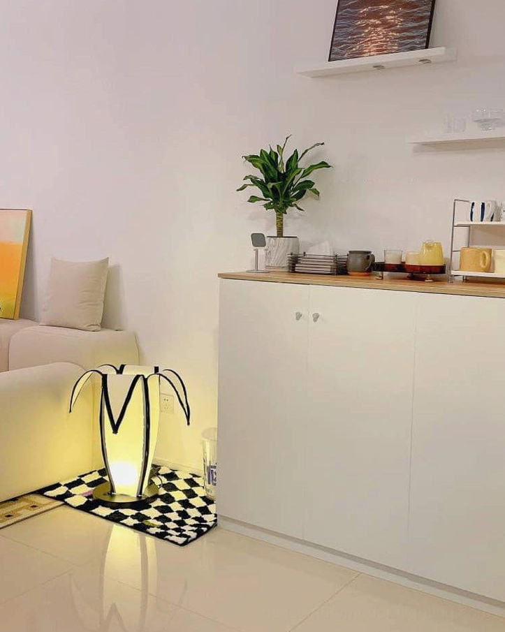 Banana desk lamp creating soft ambient light pool on minimalist furniture and accessories