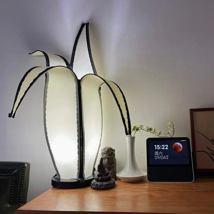 Minimalist banana table lamp on desktop with modern accessories and digital clock display