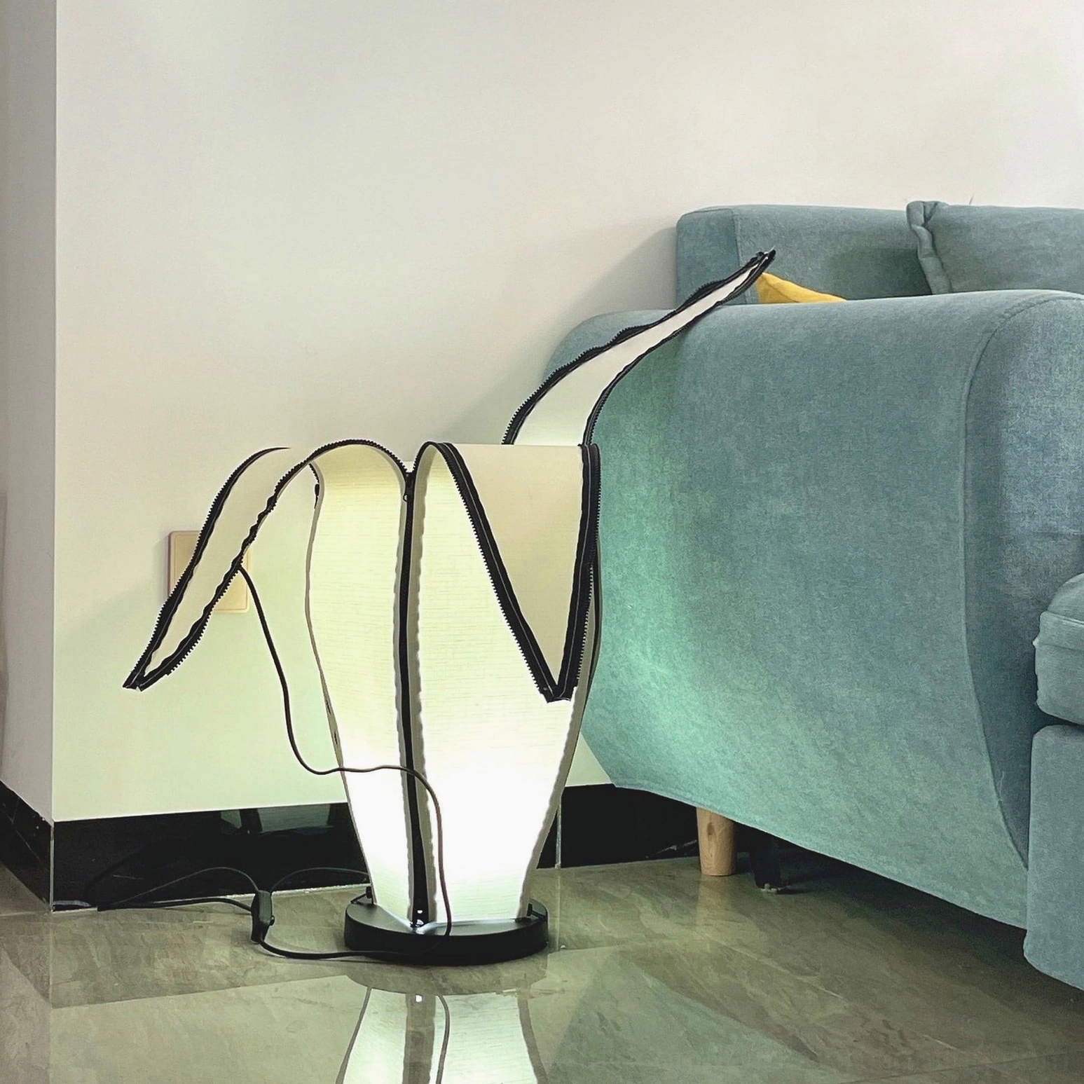 Design-focused banana table lamp with metal frame and fabric shade in neutral interior palette