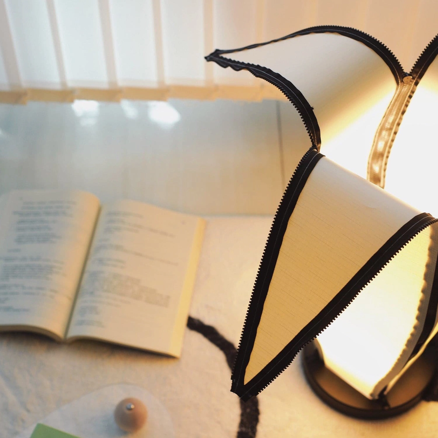 Detailed view of banana lamp fabric shade edge trim and warm illumination with decorative accessories