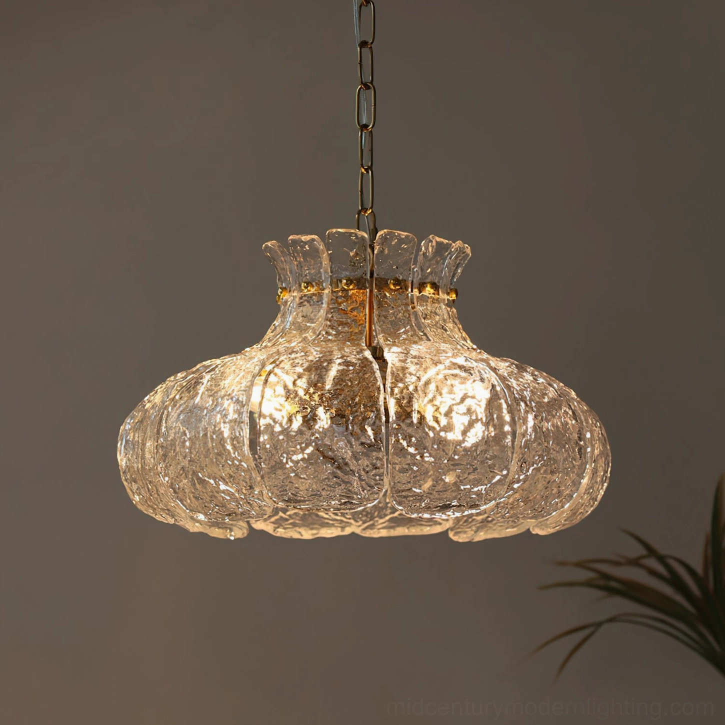 Barlas scalloped pendant light illuminated at night creating geometric shadow patterns on dining table