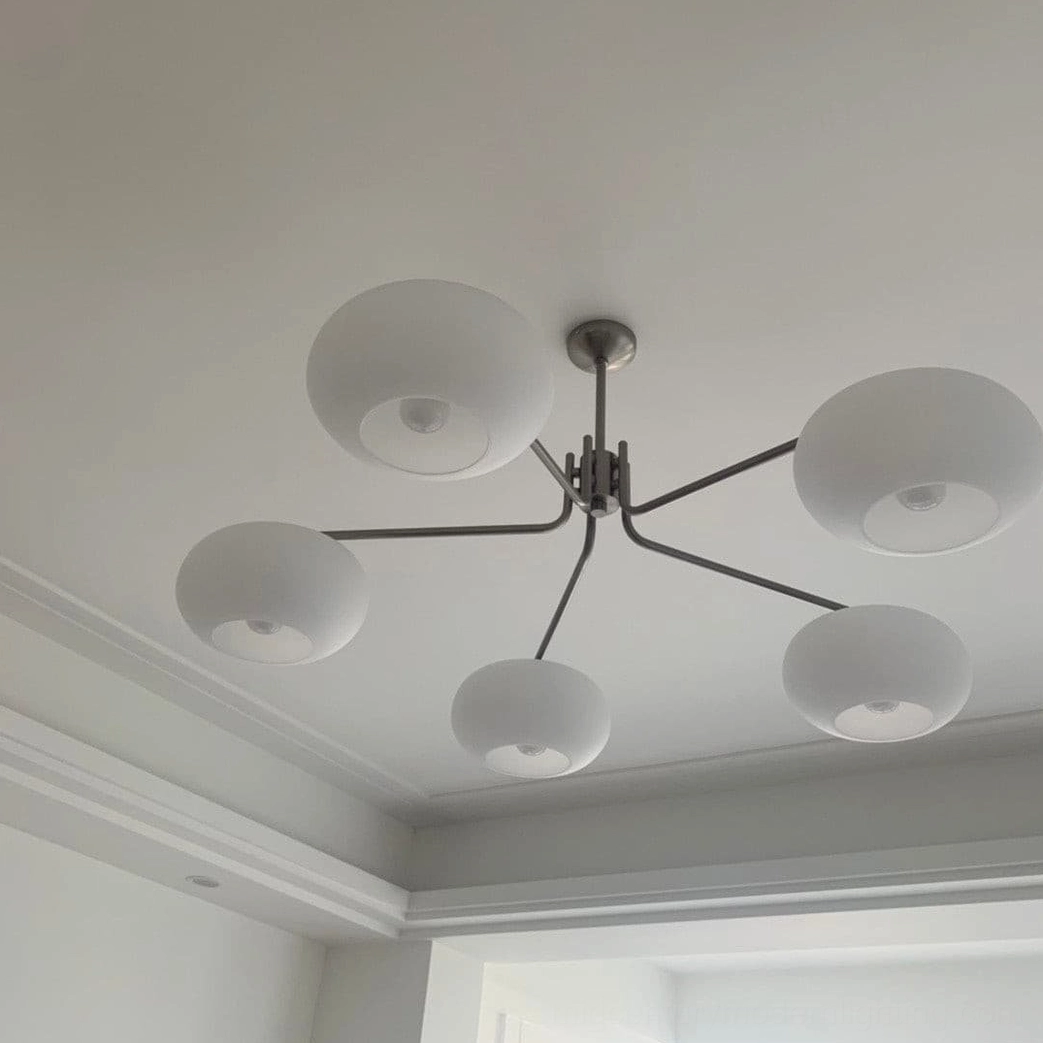 Barndon oversized 6-head frosted glass chandelier ceiling view in contemporary living room, low-angle shot showing silver metal bracket and thick matte shades
