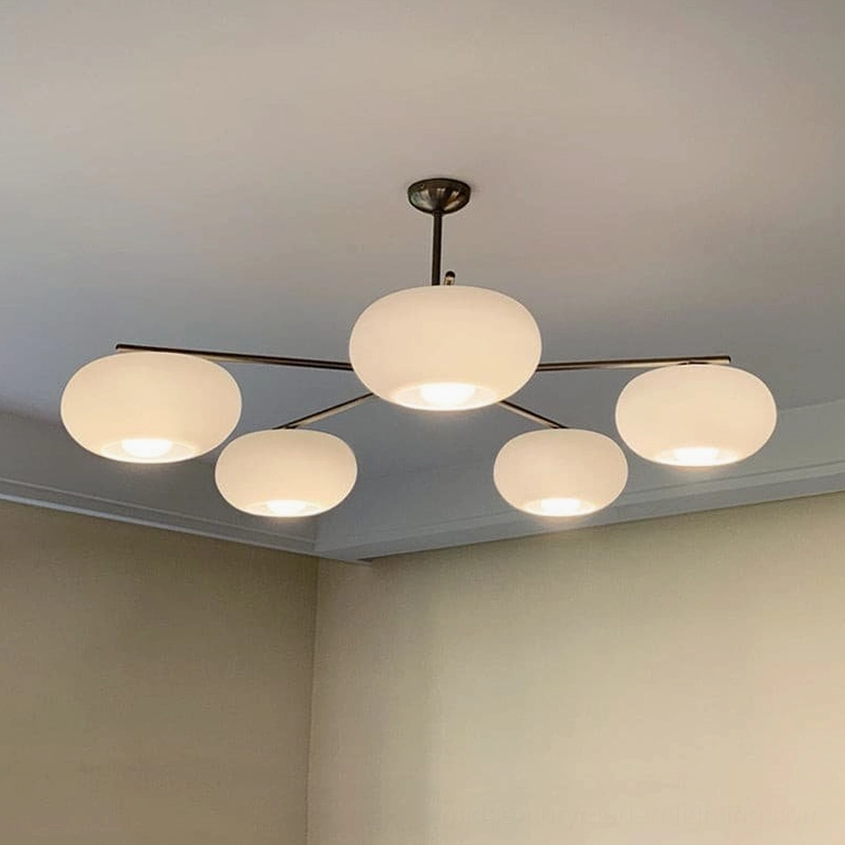 Barndon 5-head frosted glass chandelier in bedroom ceiling, low-angle view with dark bronze metal frame and warm white lighting