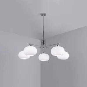 Barndon industrial chandelier installed in minimalist apartment corner, showing warm ambient lighting effect with chrome metal finish