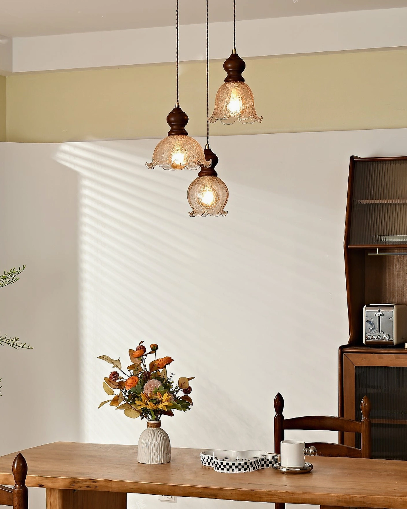 Three Barron vintage pendants with offset hanging arrangement in dining space with side cabinet