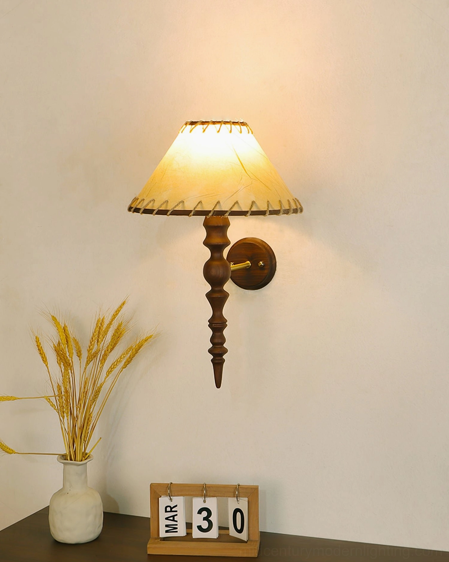 Lit Basica wooden wall lamp in bedroom corner with wheat bouquet and decorative plaque