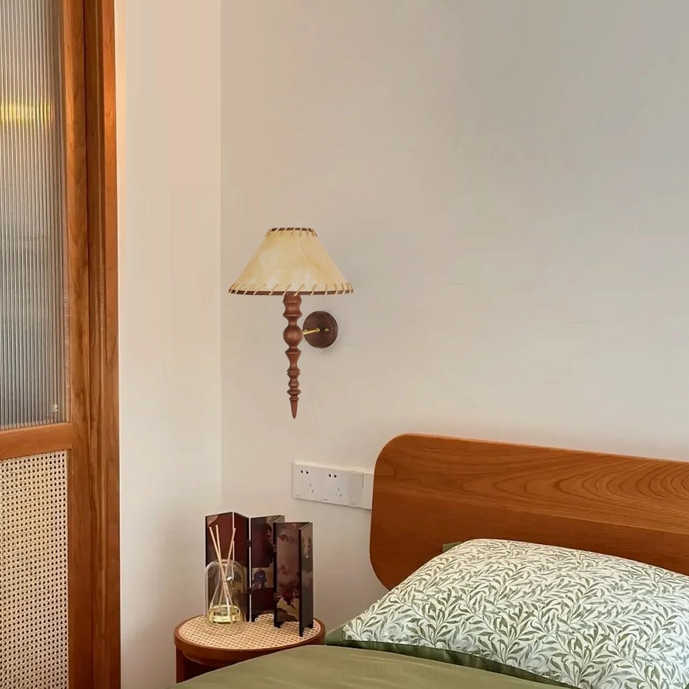 Basica solid wood wall lamp installed on bedroom wall near wooden door with side table