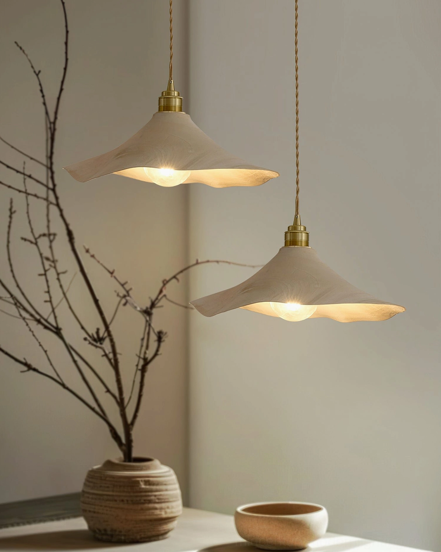 Two Baxter wabi-sabi pendant lights in Japanese-style home corner with dried branch table decor and neutral tableware styling