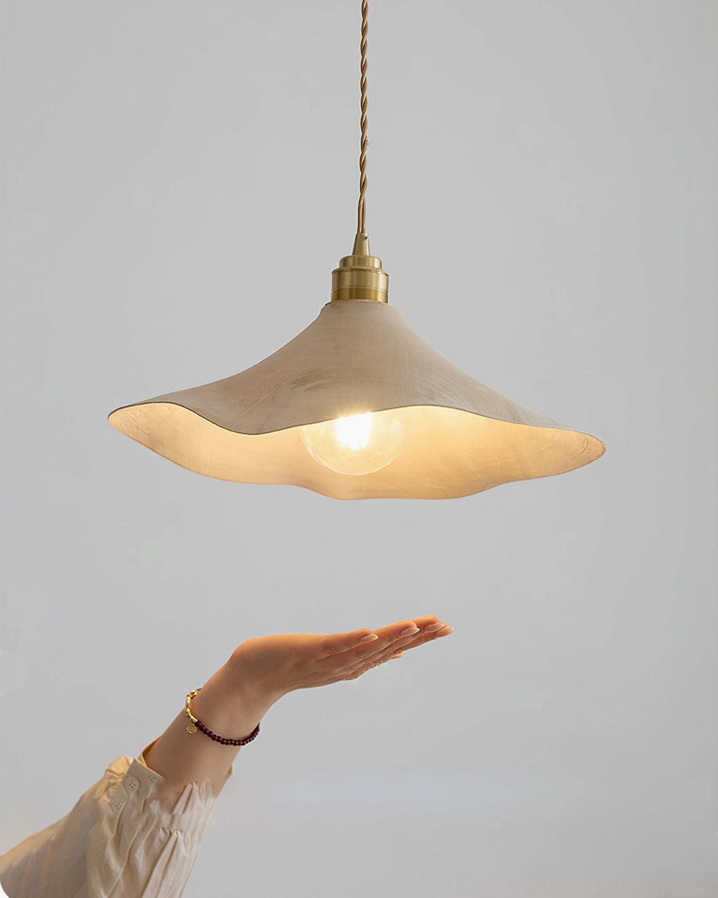 Baxter pendant light with hand and bracelet for scale comparison showing fixture dimensions and exposed Edison bulb design