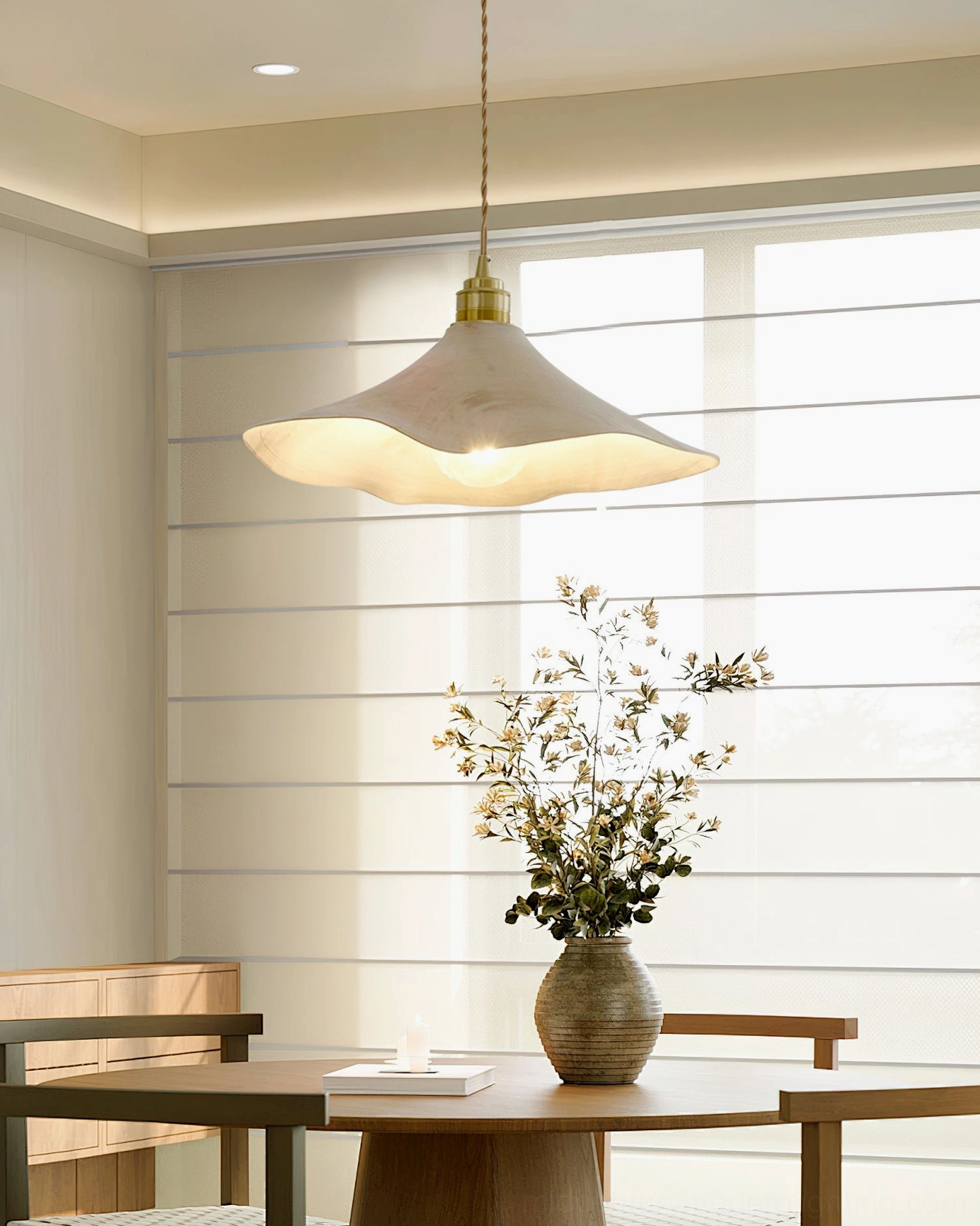 Baxter organic wave pendant light hanging in sunlit dining nook with natural window light, showing ambient glow and sculptural form