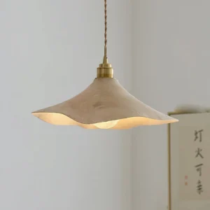 Baxter wabi-sabi pendant light close-up three-quarter view showing twisted brass hanging cord and warm glowing interior light