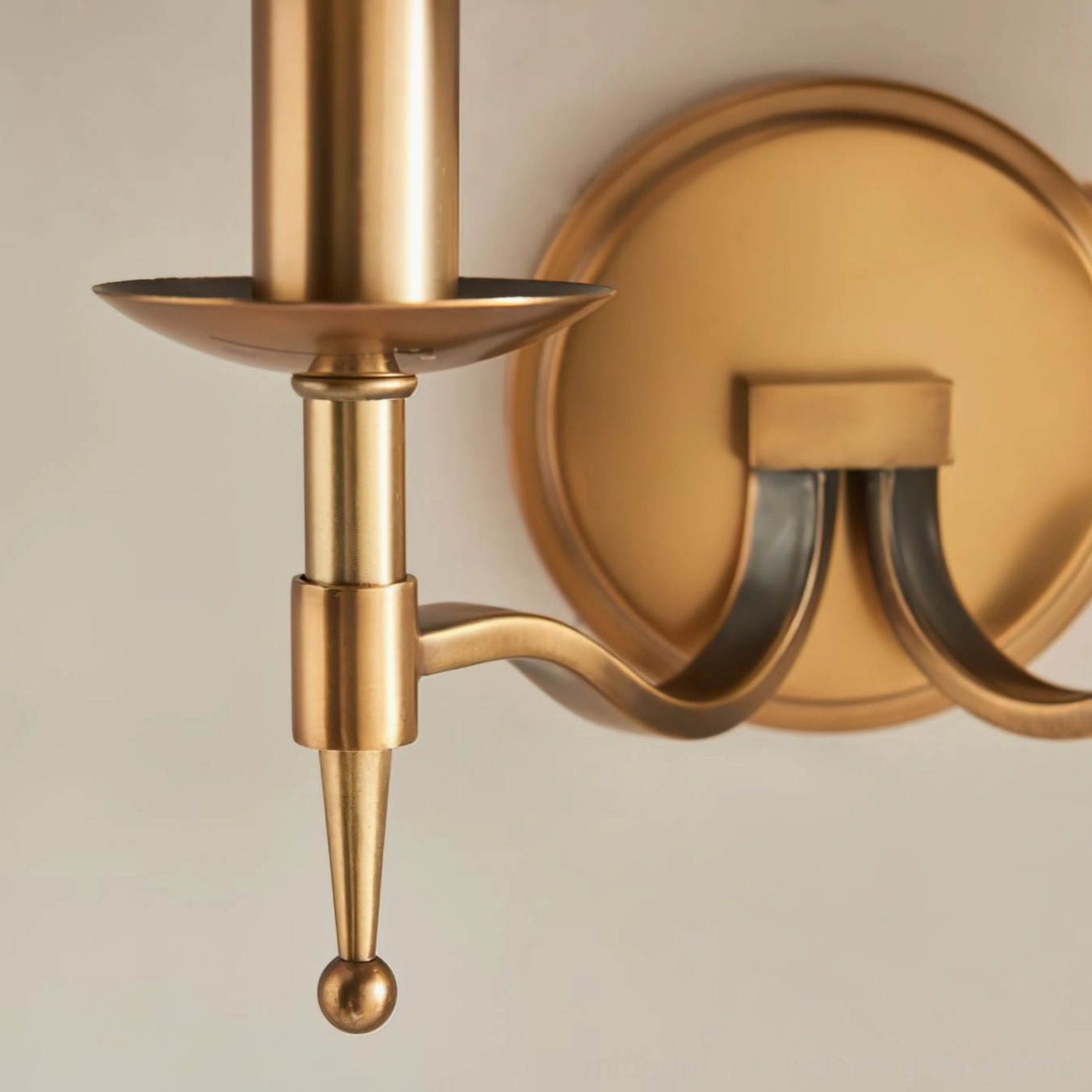 Close-up detail of Baylor dual curved brass arms and round wall mounting plate