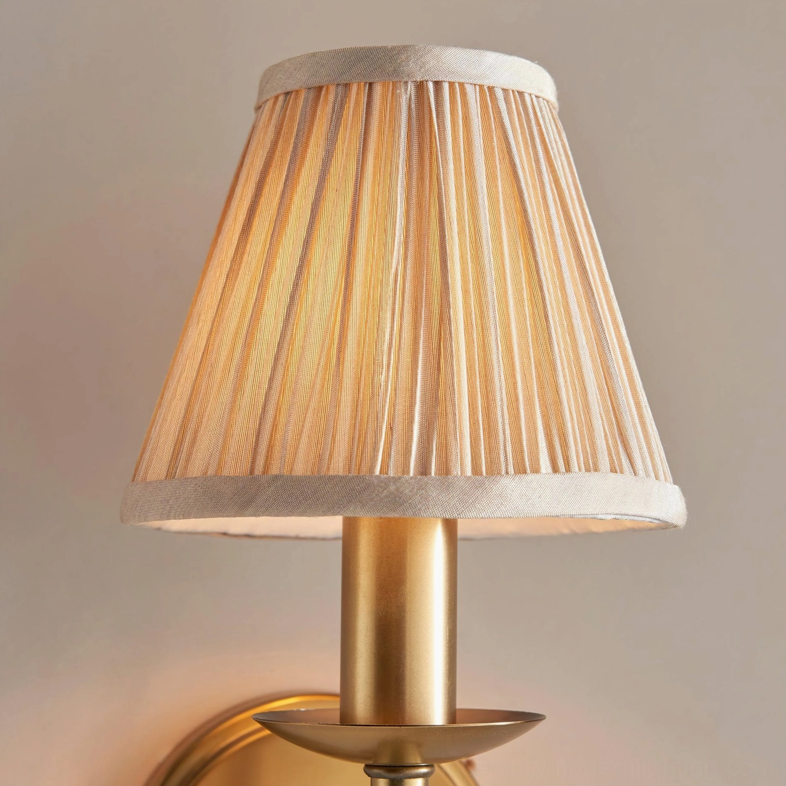 Close-up overhead view of Baylor pleated fabric shade showing hand-pleated beige texture and brass stem detail