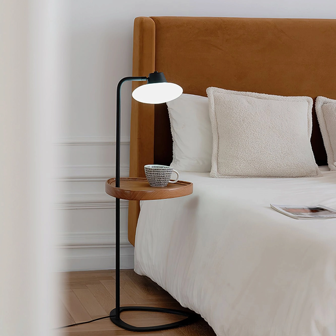 Beatrix floor lamp bedside tray with ceramic cup, bedroom with upholstered brown headboard, warm glowing light